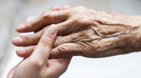 Youthful hand holding an elder hand