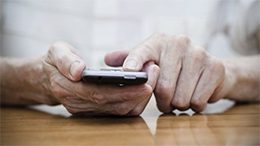 Close up of elder hands using a cell phone.