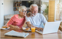 Couple at table looking at laptop