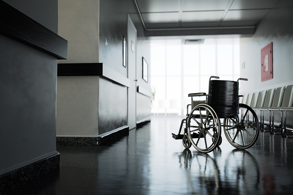 Standard manual wheelchair standing in empty hospital corridor